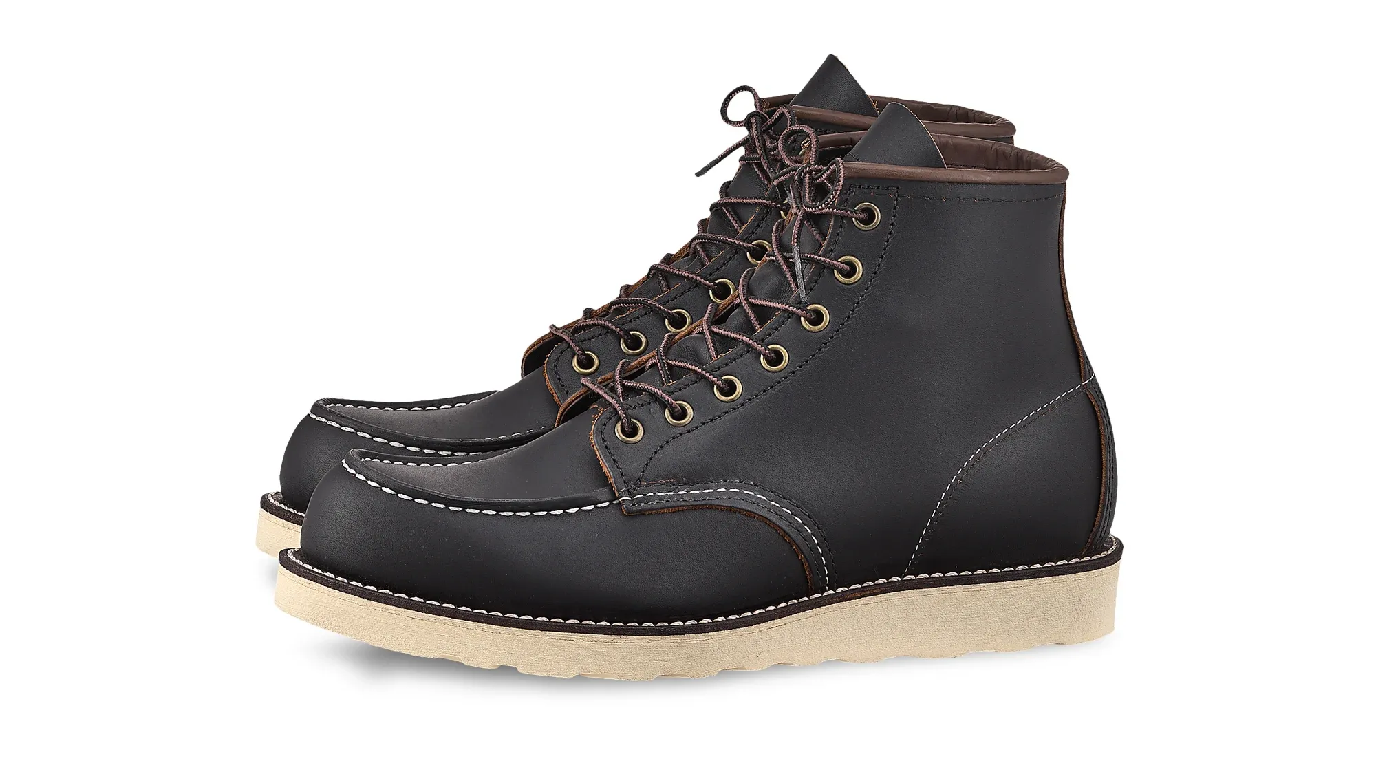 Black leather moc toe boot with brown laces and a cream wedge sole