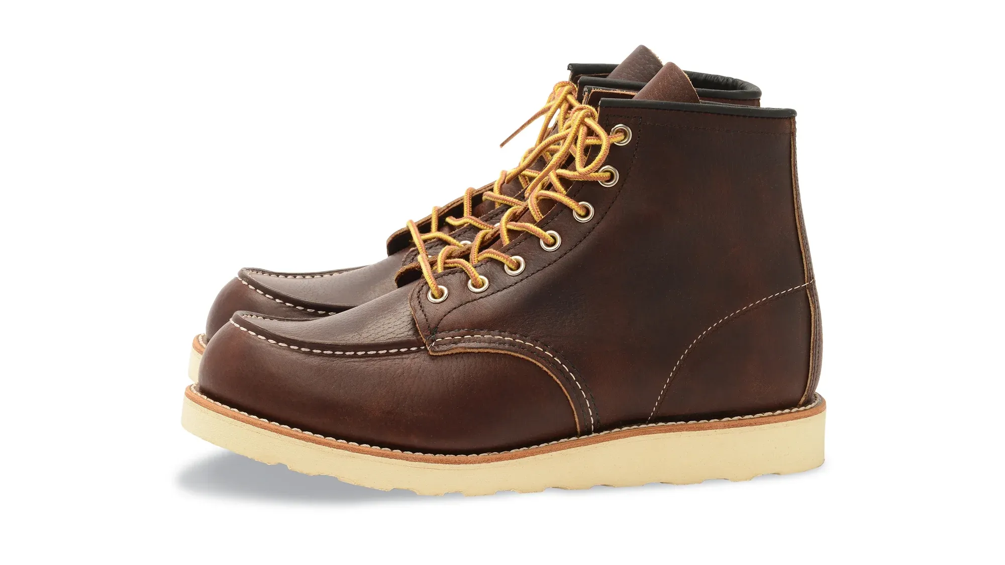 Dark brown leather moc toe boot with yellow laces and a cream wedge sole