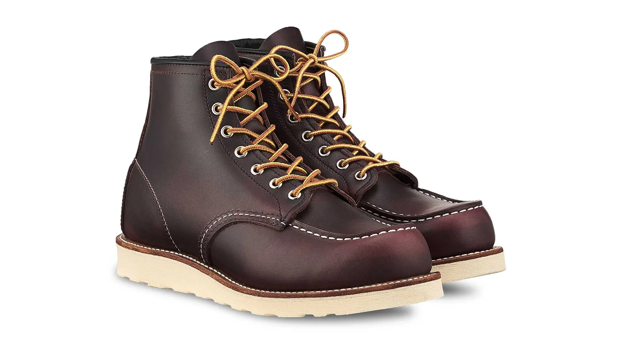 A pair of oxblood leather moc toe boots on cream wedge soles, seen from the front at an angle