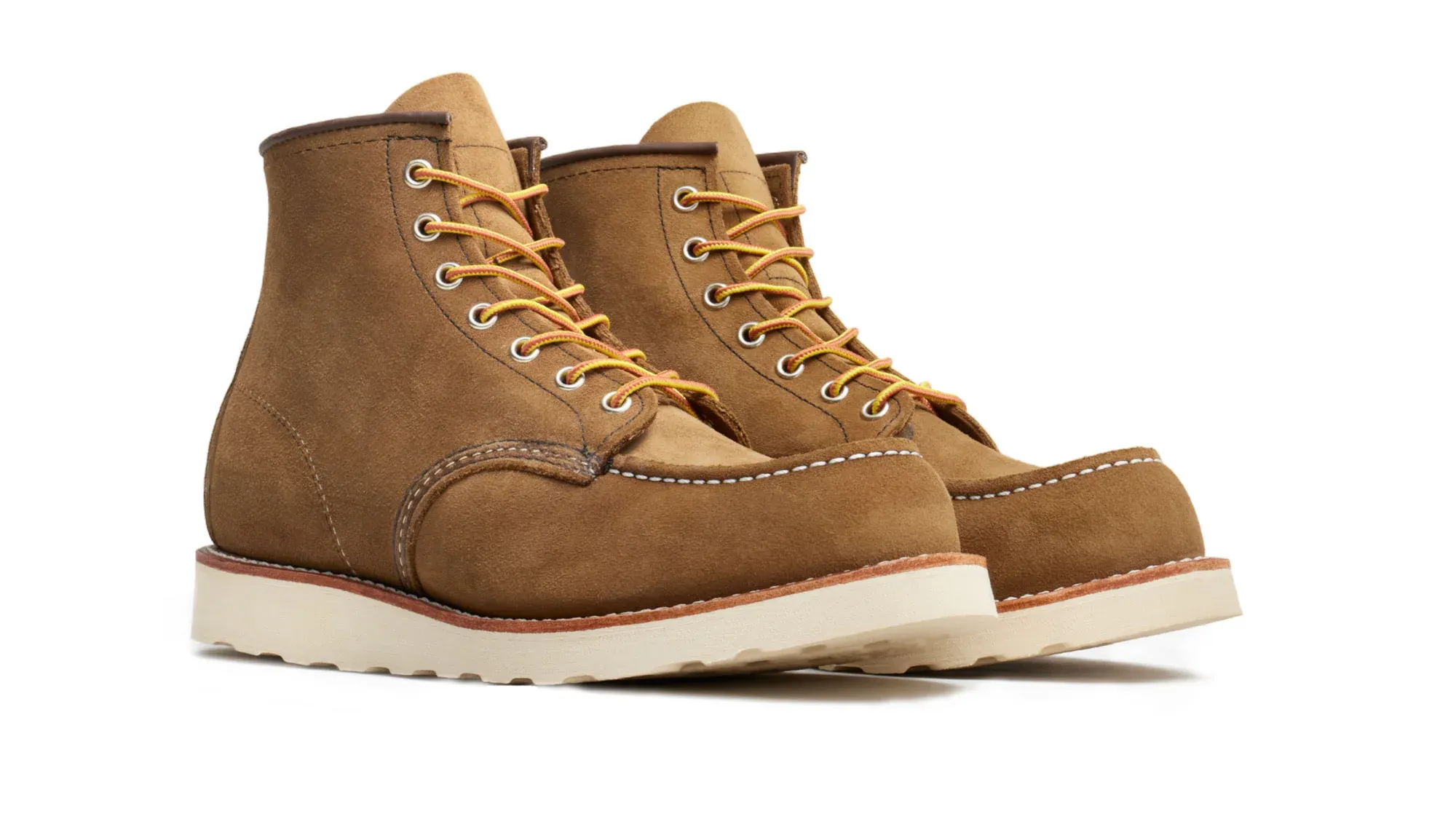 A pair of olive roughout suede moc toe boots on cream wedge soles, seen from the front at an angle