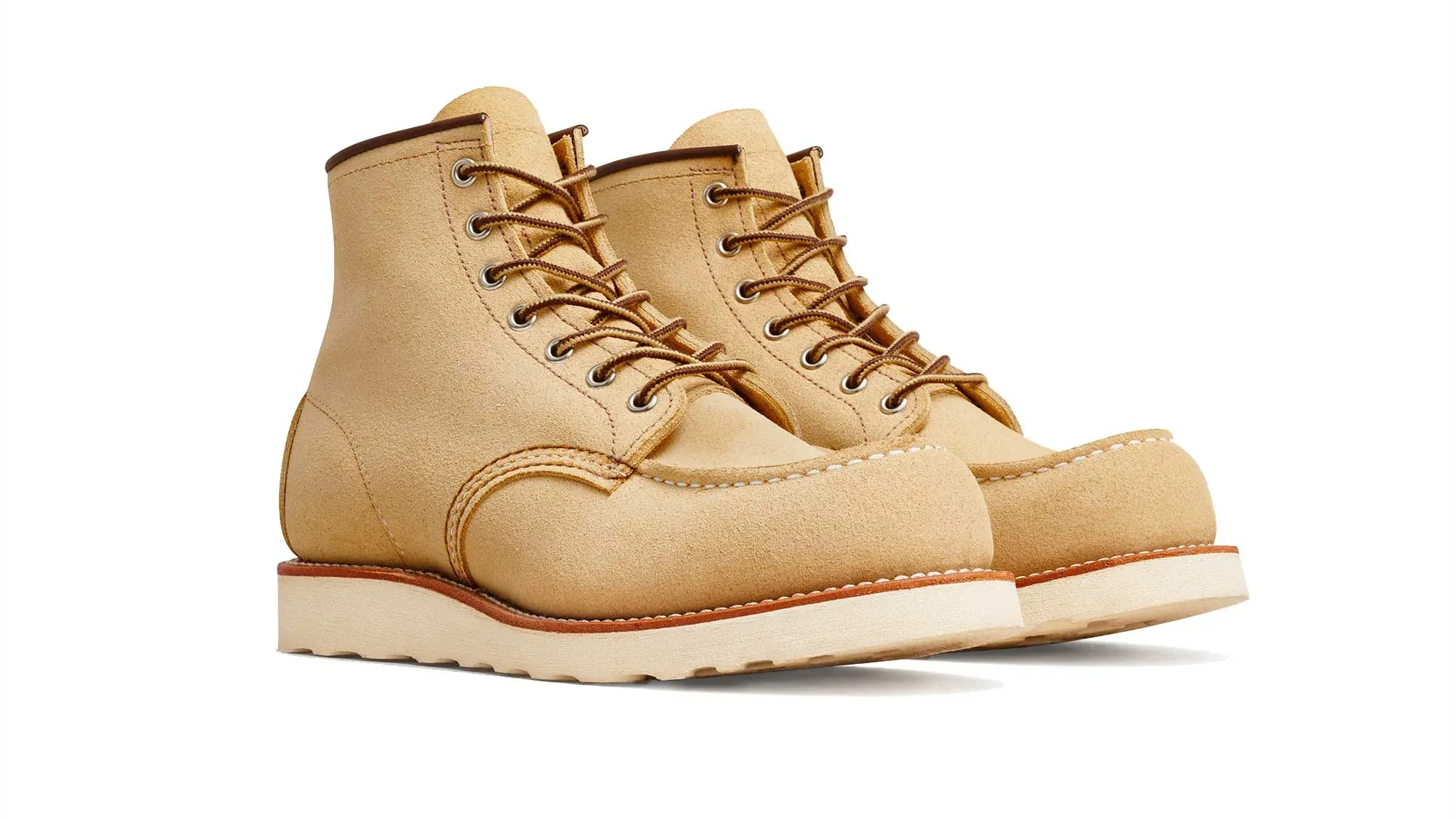 A pair of sand roughout suede moc toe boots on cream wedge soles, seen from the front at an angle