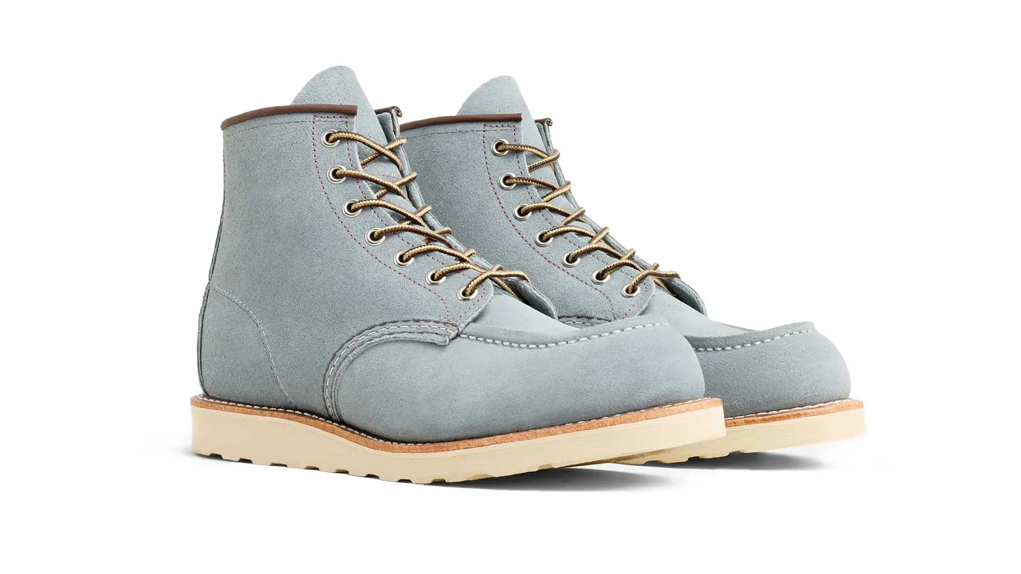 A pair of sky roughout suede moc toe boots on cream wedge soles, seen from the front at an angle