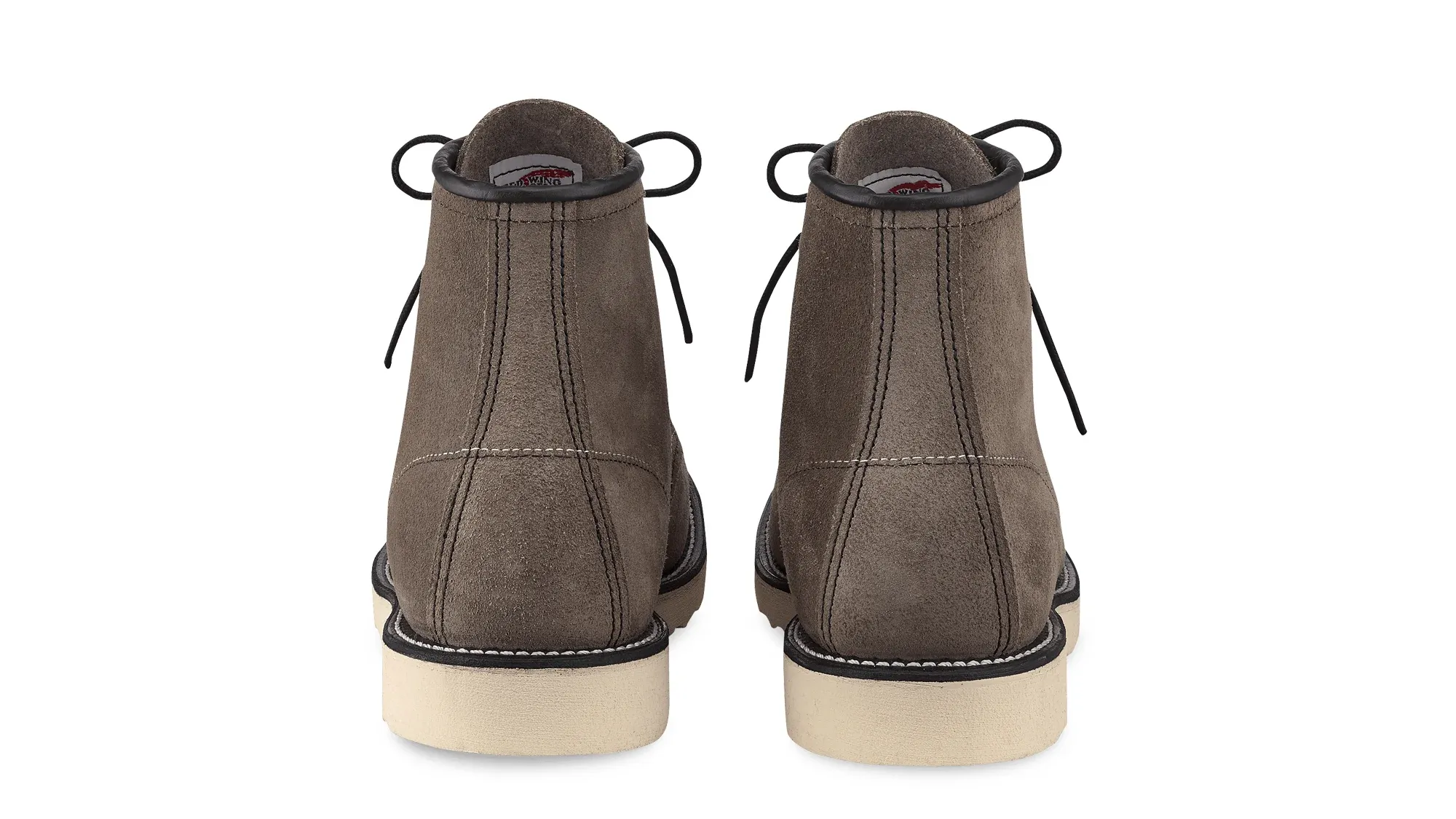 A pair of slate roughout suede moc toe boots on cream wedge soles, seen straight on from the heels
