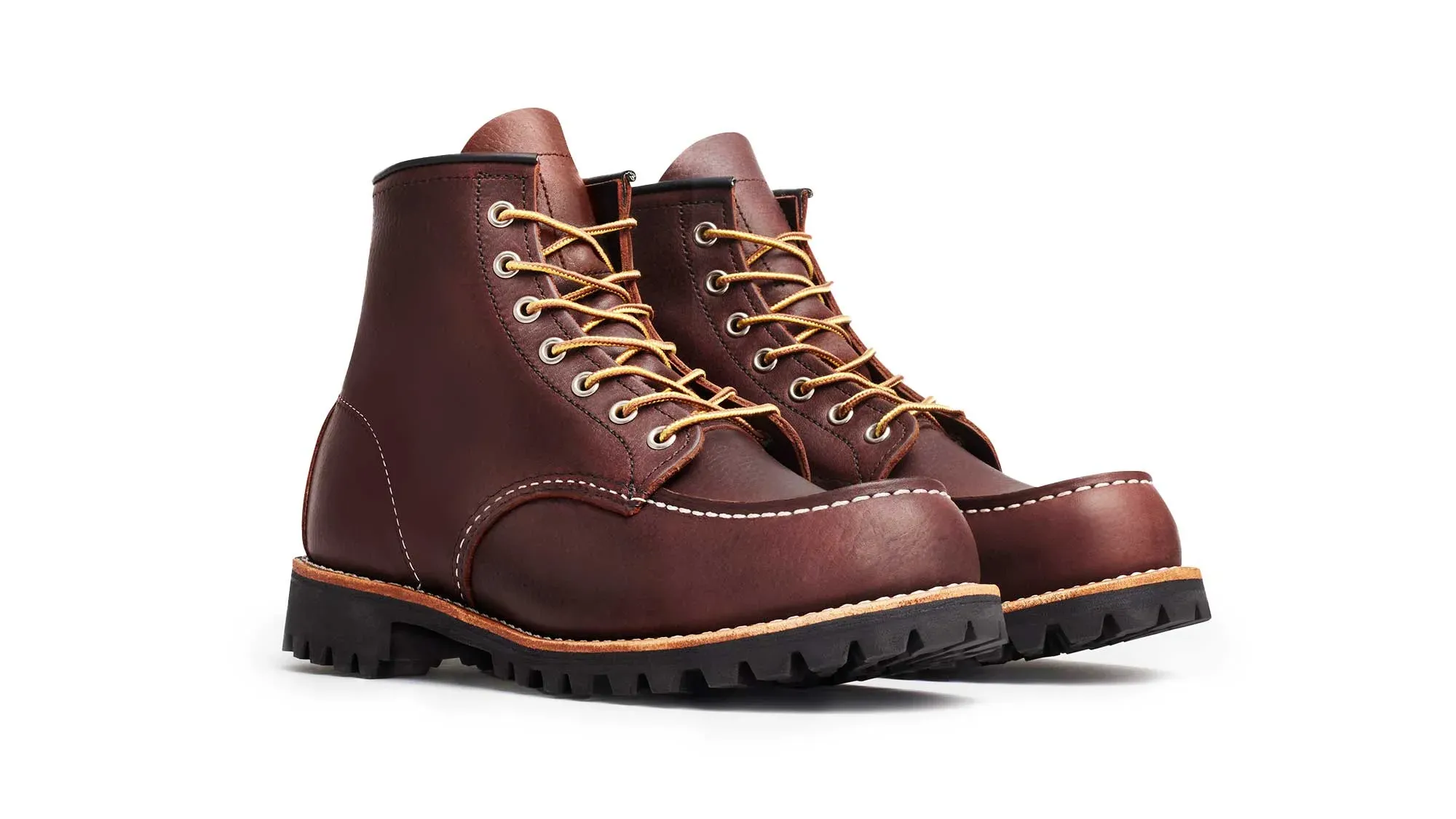 A pair of oxblood leather moc toe boots on black lug soles, seen from the front at an angle