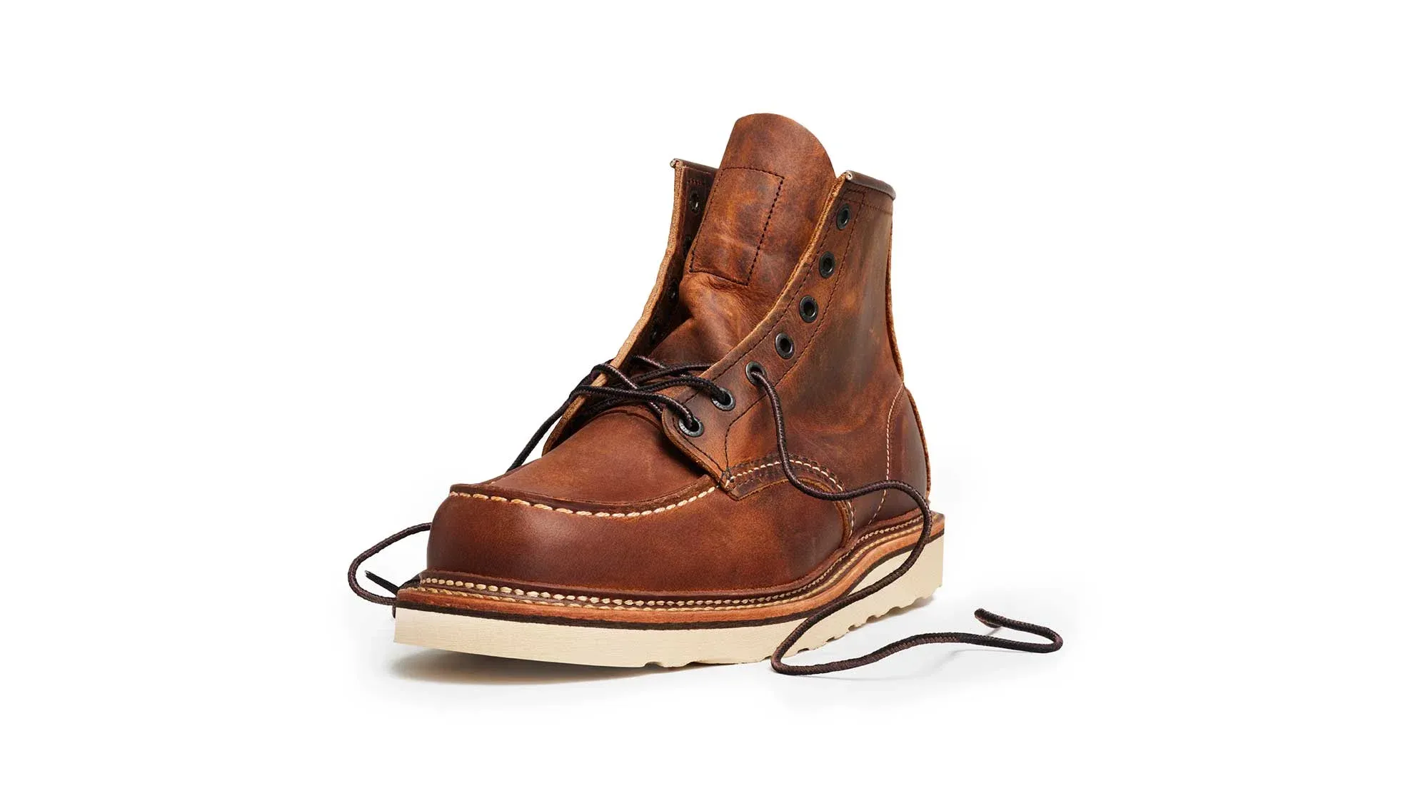 A copper leather moc toe boot on a cream wedge sole, with its laces undone
